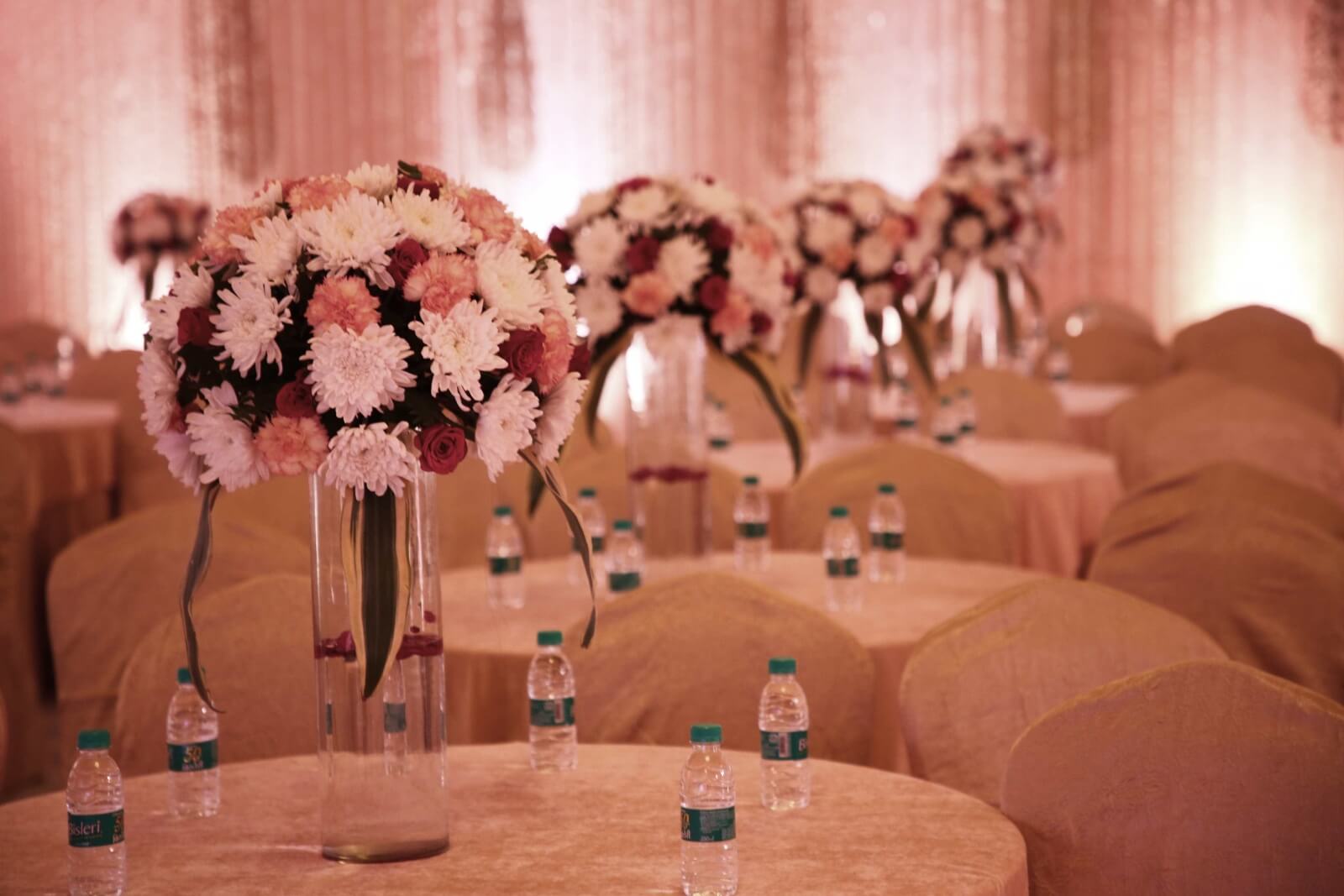 Close-up of elegant floral centerpieces at a wedding banquet in EllBee Ganga View, Rishikesh, showcasing exquisite flower arrangements in a luxurious setting.